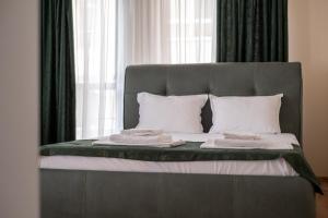 a bed with white pillows and a gray head board at 5 Villa Vitosha Classic Stays in Hisarya