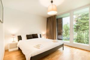 Arni AlpにあるRIVER Apartmentの大きなベッドと大きな窓のある寝室