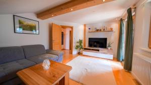 a living room with a couch and a tv at Haus Röthelsteinblick in Bad Aussee