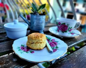 a pastry on a plate on a table with a cup at Dogs and Cats Friendly Everything English Home in Brinchang