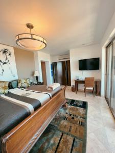 a bedroom with a large bed and a flat screen tv at Luxury Cabo Villa Stunning Ocean Views in Cabo San Lucas