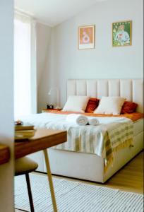 un letto bianco in una camera da letto con tavolo di Kątowa Studio - Sauna, AC, balcony a Cracovia