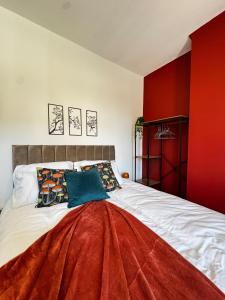 a bedroom with a large bed with a red wall at Cosy Escape Near Nature & Town 