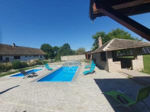 a swimming pool with lounge chairs next to a house at Klágya Vendégház in Dávod