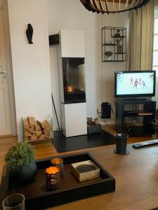 una sala de estar con un televisor y una mesa en Central on Beitostølen with walking distance to everything, en Beitostølen