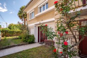 ブゾンにあるVilla Seineの赤い門と赤い花の茂みのある家