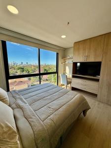 a bedroom with a large bed and a large window at Matrisa Boggiani 805 - Vivelite in Asuncion