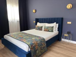 Bett mit blauem Kopfteil in einem Schlafzimmer in der Unterkunft ROOT by the River in Pedorido