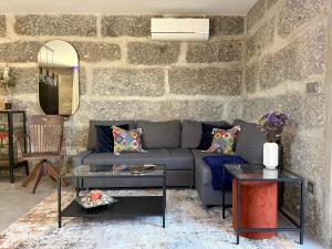 ein Wohnzimmer mit einer Couch und einer Steinwand in der Unterkunft ROOT by the River in Pedorido