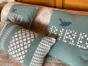 ein Bett mit Kissen mit dem Wort Kaninchen darauf in der Unterkunft 85 m2 de plain-pied, 2chambres, 3 lits dans maison confortable avec vue sur la vallée et les Pyrénées ariégeoises, grande terrasse avec barbecue et parking gratuit in Castéras