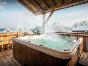 una vasca idromassaggio su un ponte nella neve di Chalet Keramis - OVO Network a La Rivière-Enverse