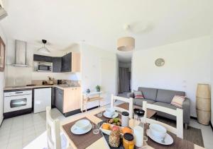 a kitchen and a living room with a dining room table at T2 near lake,pool,terrace in Soustons