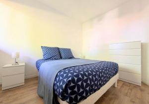 a bedroom with a bed with blue and white sheets at T2 near lake,pool,terrace in Soustons +11 photos