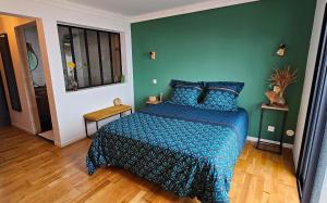 a bedroom with a bed and a green wall at La Kaz JJ in Le Tampon