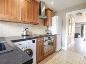 eine Küche mit Waschmaschine und Geschirrspüler in der Unterkunft Sunnyfield Cottage in Coulsdon