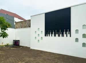 a white building with a black window on it at Casa De Cuentos Bali in Denpasar