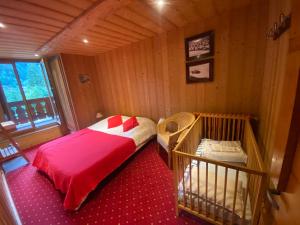 een kleine kamer met een bed en een wieg bij Joyeux Flocon - Spacieux chalet in Les Contamines-Montjoie