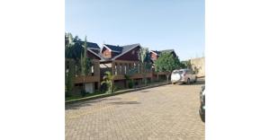 a street with houses and a car parked on the road at Fairways Hotel in Narok