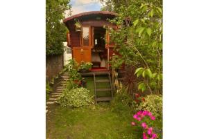 a tiny house in a garden with flowers at The Gypsy Knot in Wells next the Sea
