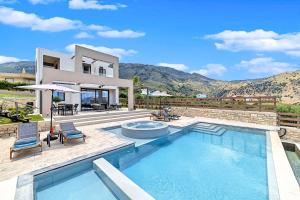 a villa with a swimming pool and a house at Minaos in Kournás