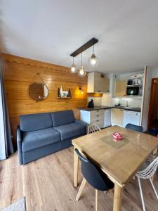a living room with a blue couch and a table at La cime de valmi - A deux pas du front de neige in Valmeinier
