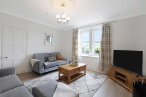 a living room with a couch and a flat screen tv at Cuddy's Croft - North East Escapes in Bellingham