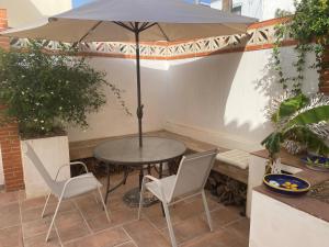 een tafel en twee stoelen en een parasol op een patio bij 4 Bedroom Villa in Arroyo in Benalmádena