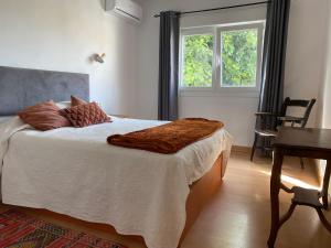 een slaapkamer met een bed met witte lakens en een raam bij 4 Bedroom Villa in Arroyo in Benalmádena +31 foto's