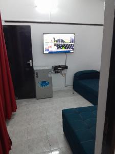 Habitación con TV de pantalla plana y sofá. en Jaycee Holdings Properties, en Mombasa 2 fotos más