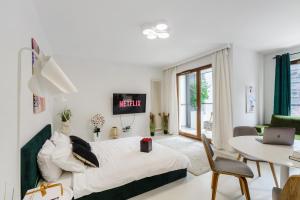 a bedroom with a bed and a table with a laptop at Lumina Deluxe Warsaw in Warsaw