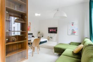 a living room with a green couch and a bedroom at Lumina Deluxe Warsaw in Warsaw +12 photos