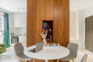 a kitchen with a white table with a laptop on it at Lumina Deluxe Warsaw in Warsaw