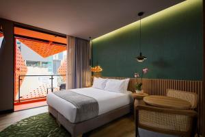 a hotel room with a bed and a large window at Calle Flora Hotel by Jalo in Medellín