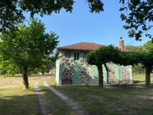 ein Haus mit einem grünen Tor im Hof in der Unterkunft La Landaise in Castets