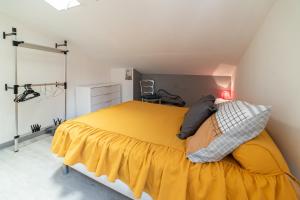 een slaapkamer met een bed met een gele deken bij Villa Marie Carmen in Rivesaltes