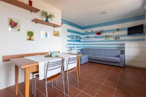 cocina con mesa, sillas y sofá en IseoLakeRental - Dream House, en Riva di Solto