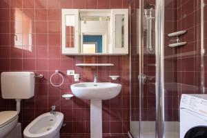 Un baño con lavabo, inodoro y espejo. en IseoLakeRental - Dream House, en Riva di Solto 11 fotos más