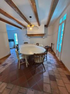 ein Esszimmer mit einem weißen Tisch und Stühlen in der Unterkunft La Landaise in Castets