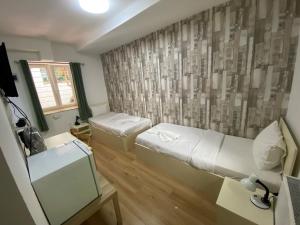 a small room with two beds and a window at Easy Star Hotel in Budapest