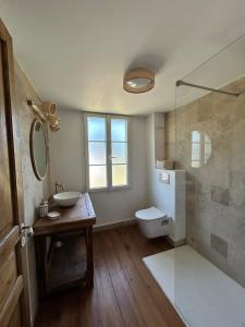 ein Badezimmer mit Waschbecken, Toilette und Spiegel in der Unterkunft La Landaise in Castets