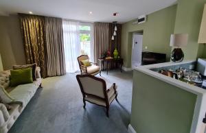 a living room with a couch and a table and chairs at Palm Grove Apartments in Torquay