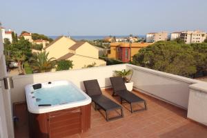 a hot tub on a balcony with two chairs at Villa Llevant in Miami Platja