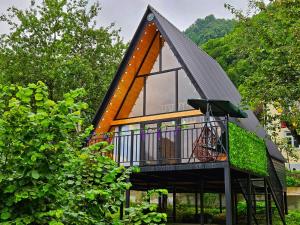 ein Haus mit Walmdach und Balkon in der Unterkunft Cottage Mziuri in Tsʼkhemlisi