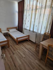 a room with a bed and tables and windows at Buking in Novi Sad