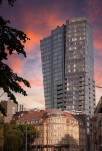 a tall building in a city with a sunset at HANZA TOWER GOLD 19th Floor in Szczecin