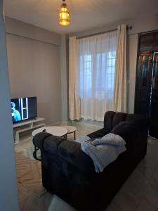 ein Wohnzimmer mit Sofa und Fernseher in der Unterkunft Still&Simple in Nanyuki