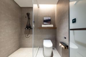 Atour Hotel Suzhou Jinji Lake East Park High-Speed Rail Station في سوتشو: حمام مع مرحاض ودش زجاجي