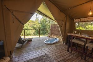 a tent with a hot tub on a wooden deck at Windermere - Safari Suite in Ambleside