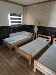 a room with two beds and a table with a lamp at Buking in Novi Sad