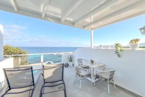 a patio with a table and chairs and the ocean at Casa Burgao Studio with large seaview terrace in Punta de Mujeres